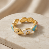 Chromatic Evil Eye Eternity Ring - angled view on marble pedestal showing blue, pink, white and navy enamel eyes with crystal pupils