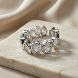 Larme Pear Crystal Eternity Ring - angled top view on marble showing continuous pear crystal bezel band