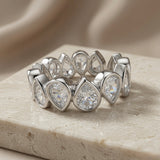 Larme Pear Crystal Eternity Ring - front elevated view on marble with silk backdrop showing pear crystal brilliance