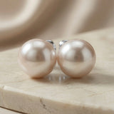 Perle Blush Pearl Stud Earrings Silver - front view pair on marble with silk backdrop showing full blush pearl lustre on silver posts