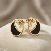 Lunaire Noir Crystal Stud Earrings - pair on sand surface showing full circular disc profile and butterfly backs