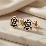 Camélia Noir Crystal Earrings - black enamel stud style pair on marble with silk showing camellia rose and side crystal accent