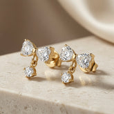 Noeud Crystal Bow Drop Earrings - pair side angle on travertine showing bow silhouette, gold link and drop length