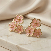 Sakura Bloom Cluster Stud Earrings - pair flat lay on marble with silk showing full blush pink enamel cluster composition and gold borders