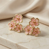 Sakura Bloom Cluster Stud Earrings - pair flat lay on marble with silk showing full blush pink enamel cluster composition and gold borders