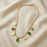 Pluie Verte Charm Necklace Gold & Emerald - full necklace flat lay on silk showing lobster clasp, extender chain and full charm arc