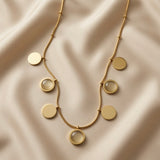 Sept Lunes Disc Station Necklace - flat lay on ivory silk showing seven disc composition from above, alternating mirror-polished gold discs and translucent moonstone cabochon circles in gold bezels