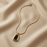 Tableau Noir Pendant Necklace - full flat lay on ivory silk showing complete snake chain, lobster clasp, gold tag extender and pendant