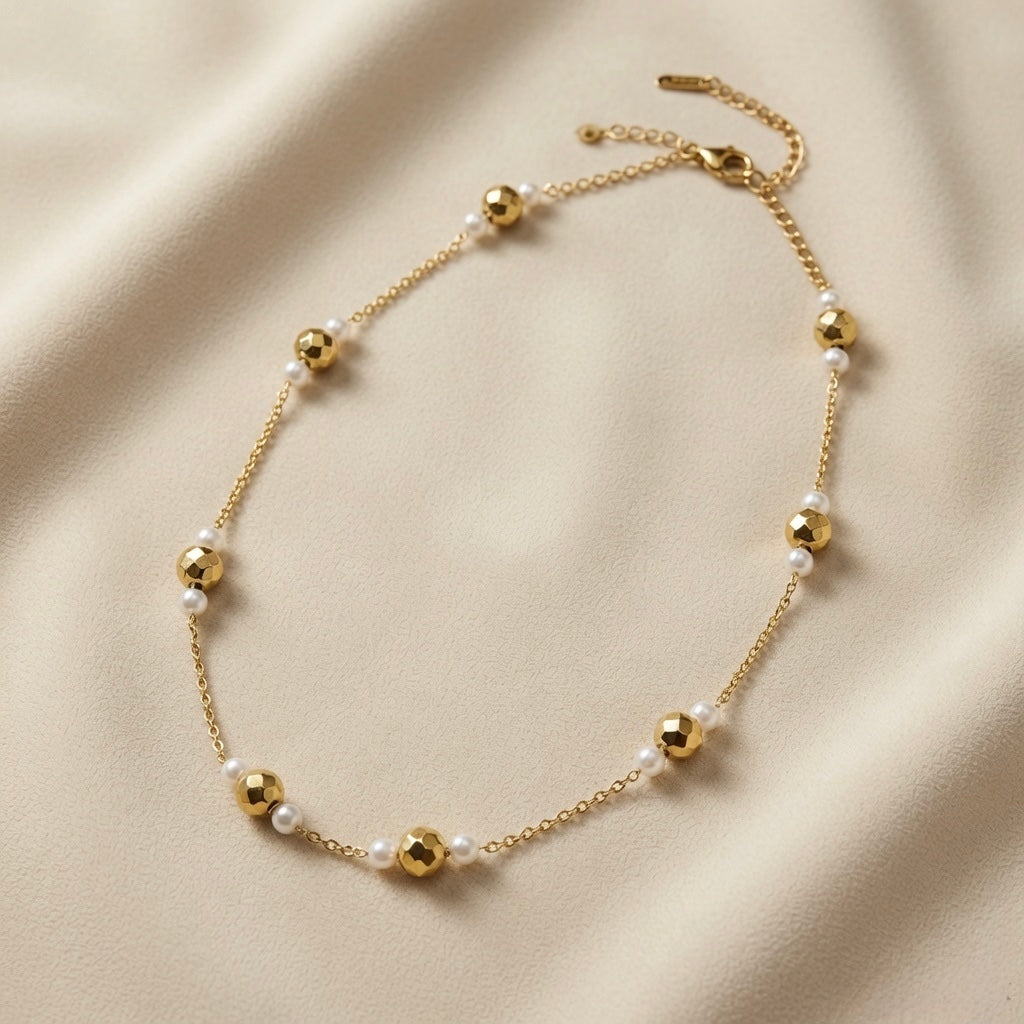 Perle Dorée Station Necklace - full flat lay on ivory silk showing complete necklace, lobster clasp and curb-link extender chain