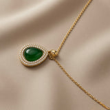 Impériale Jade Pavé Necklace - close-up on ivory silk showing pear cabochon green crystal, double halo pavé rows, gold channel and cylindrical bail detail