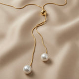 Perle Bolo Lariat Necklace - close-up on ivory silk showing gold ball slider, two snake chain tails and two freshwater pearl drops