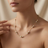 Perle Dorée Station Necklace - worn on model collarbone showing alternating gold bead and pearl stations across décolletage at chest length