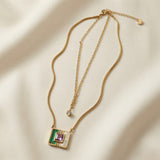 Malachite Amethyst Square Layer Necklace Set - full flat lay on ivory silk showing two necklaces: fine cable chain with single round crystal zirconia solitaire drop above and flat herringbone snake chain with large square malachite mother-of-pearl amethyst inlay pendant below, both with lobster clasps and extenders, small round disc tag on cable chain extender