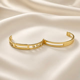 Arcade Crystal Lattice Hinged Bangle Set - both bangles flat lay on champagne silk showing complete set: crystal lattice bangle with five bezel-set crystal zirconia stones (left) and plain lattice bangle without stones (right), both showing identical wide flat-band construction with open-work geometric lattice and hinged clasp