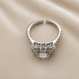 Princess Cut Double Halo Split Shank Adjustable Ring - back/underside view on ivory satin showing open adjustable band and gallery underside: open-C adjustable band back construction with pavé rails visible on both sides, layered gallery underside construction showing full ring head depth, five round brilliant white crystals visible in top row of gallery, diamond-clear marquise crystal visible at base of gallery