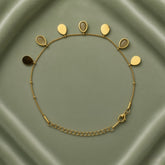 Gold Teardrop Charm Satellite Chain Anklet - full flat lay on sage green satin tray showing complete anklet in circular layout: fine gold satellite chain with evenly spaced gold ball stations carrying seven alternating teardrop charms along upper arc, solid mirror-polish gold flat teardrop charms alternating with open gold bezel nude cabochon teardrop charms, lobster clasp and curb-link extender chain at bottom right