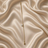 Pear Crystal Solitaire Drop Bracelet Snake Chain Gold - extreme macro on cream satin: pear-cut brilliant white crystal zirconia solitaire in four-prong gold claw setting in close detail, two smooth gold ball satellites on ribbed snake chain on each side, pure colourless diamond-like white brilliance and facet detail clearly visible