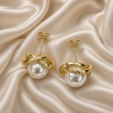 Gold Pearl Jewellery Set Pavé Crystal Interlocking Ring Pendant Necklace Stud Earrings - earrings detail on cream satin: pair of pearl stud earrings showing large round white simulated pearl cradled in two interlocking warm gold bands with micro-pavé round brilliant white crystal zirconia-set band crossing smooth warm gold band in orbital embrace around pearl, warm gold straight posts with butterfly push-back clutch fastening, cream satin background