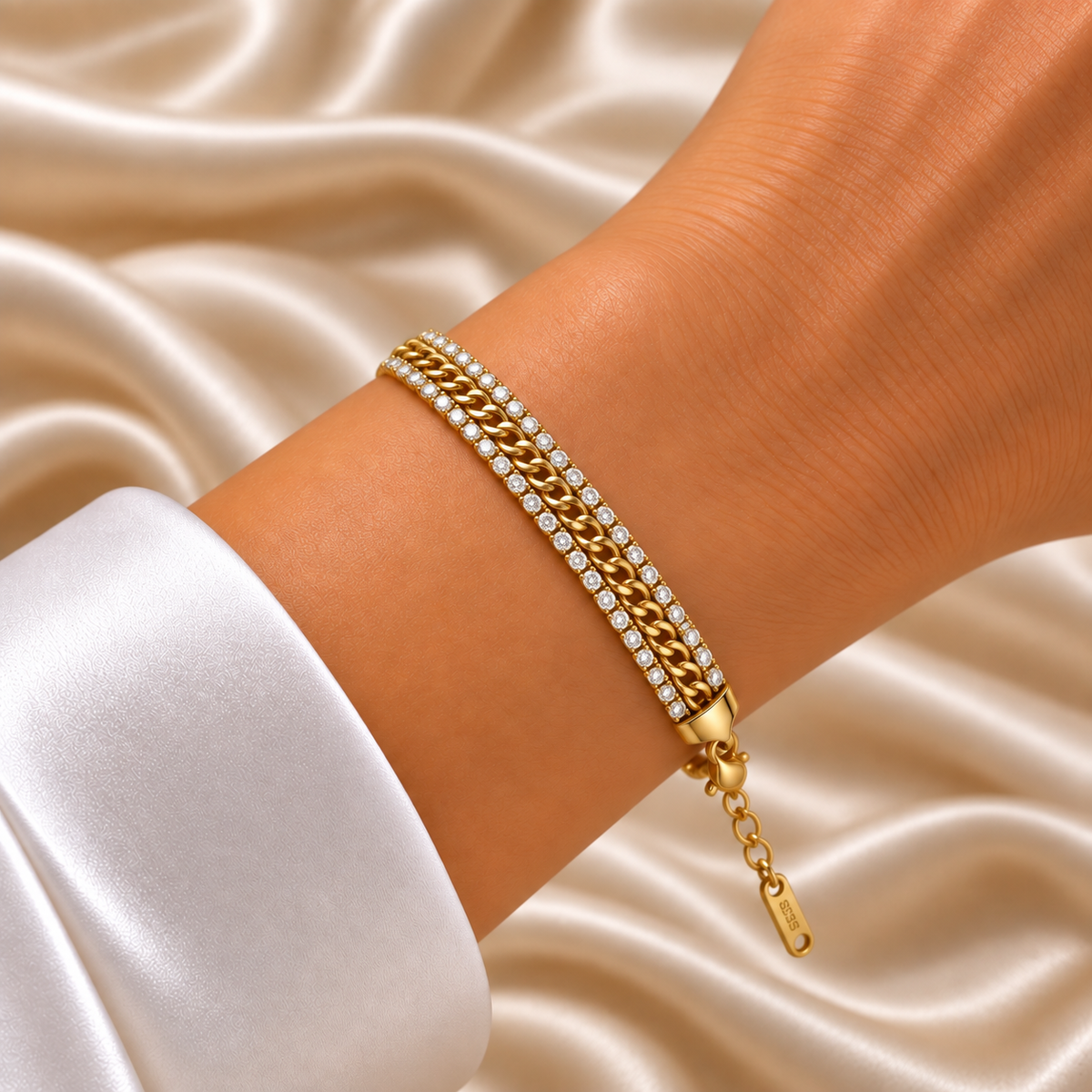 Gold Cuban Link Chain Bracelet Double Crystal Tennis Row Three Row Shield Clasp - hero overhead flat lay on cream satin: full bracelet in circular form showing three-row parallel architecture of upper round brilliant white crystal zirconia tennis row, centre flat-faced warm 18K gold Cuban curb link chain, lower round brilliant white crystal tennis row, tapered warm gold shield end caps and lobster clasp visible, cream satin background