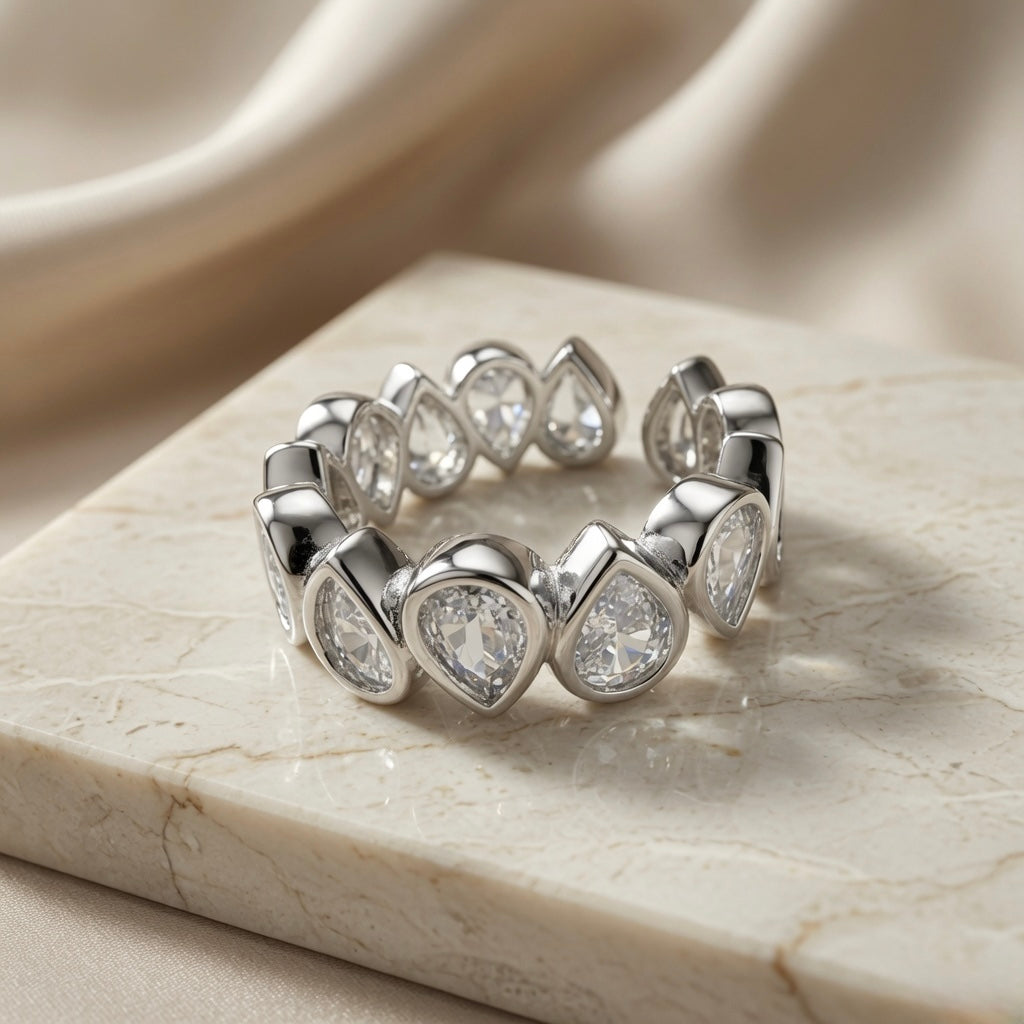 Larme Pear Crystal Eternity Ring - angled top view on marble showing continuous pear crystal bezel band