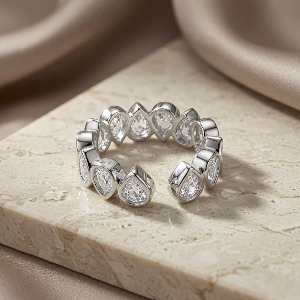 Larme Pear Crystal Eternity Ring - open back view on travertine showing adjustable band and full stone coverage