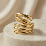 Helix Gold Coil Ring - front elevated view on travertine pedestal showing full five-coil width