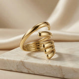 Helix Gold Coil Ring - angled view on marble with silk backdrop showing coil taper and open ends