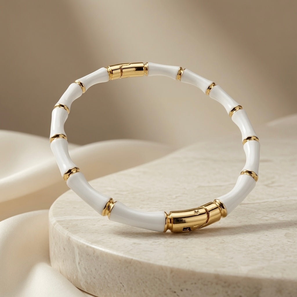Blanc Bamboo Enamel Bangle - elevated view on stone pedestal with soft backdrop
