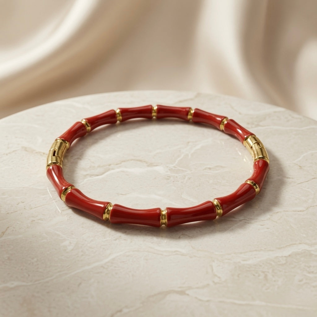 Rouge Bamboo Enamel Bangle - elevated angled view on marble pedestal with silk backdrop