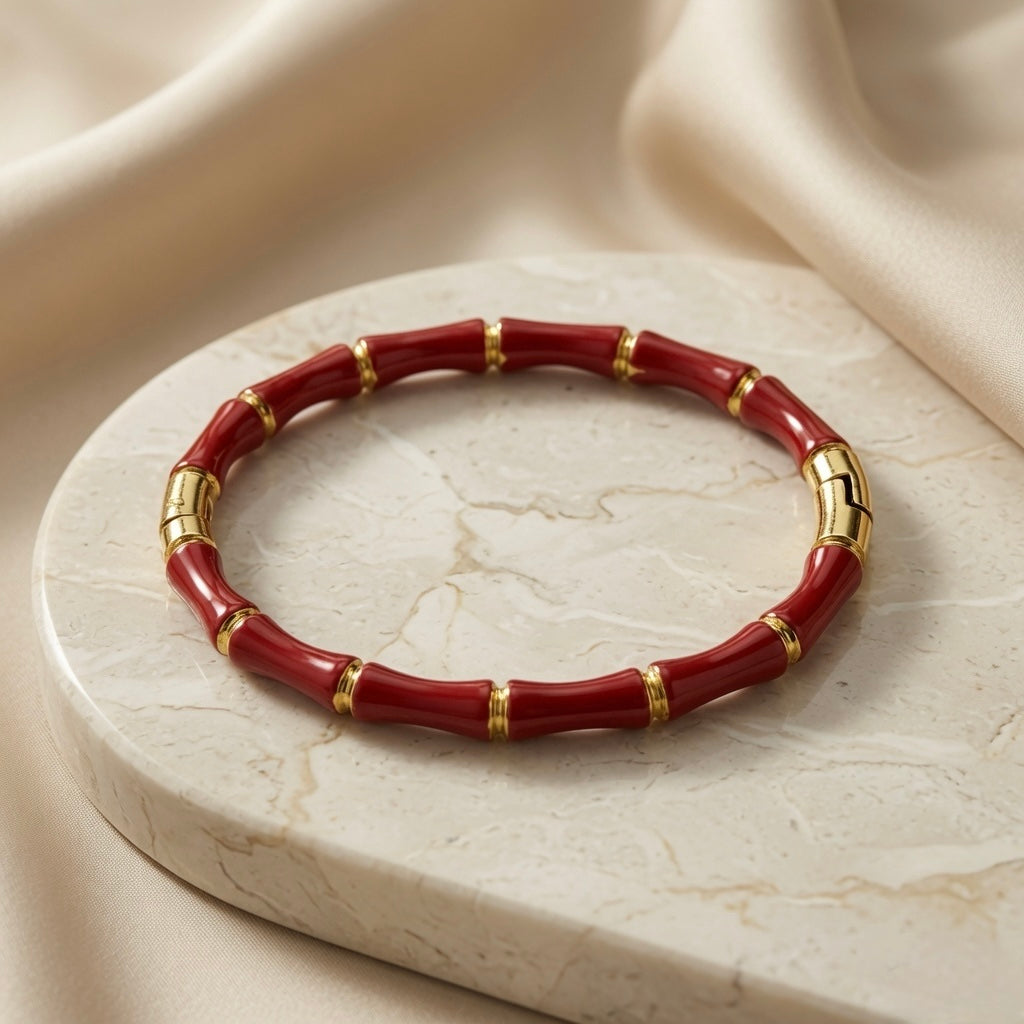 Rouge Bamboo Enamel Bangle - side angle on marble disc with silk backdrop