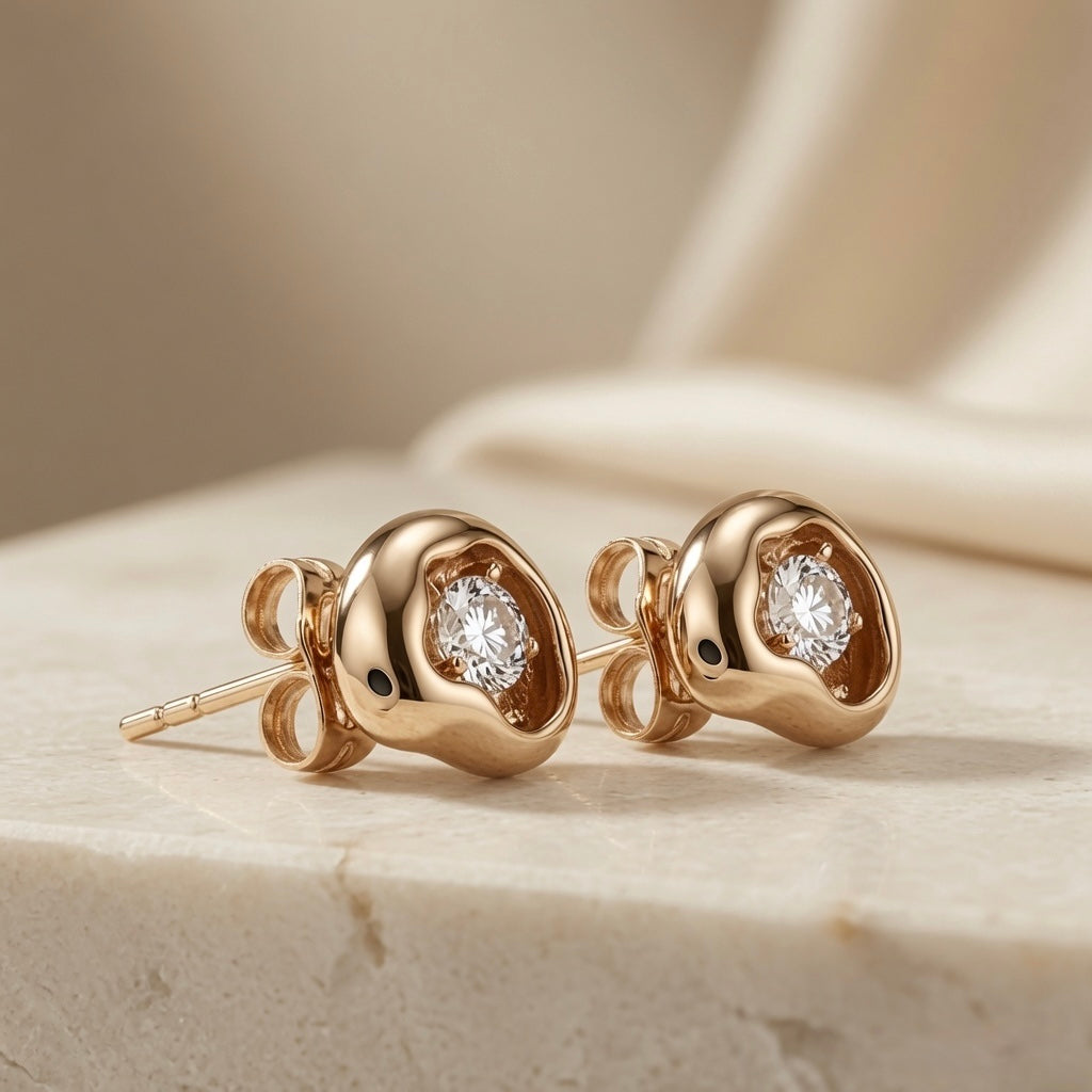 Molten Pear Crystal Stud Earrings - pair angled view showing round crystal variant with butterfly backs on marble