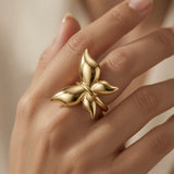 Fleur Gold Bloom Ring - worn on model hand showing knuckle-spanning bloom and warm gold glow