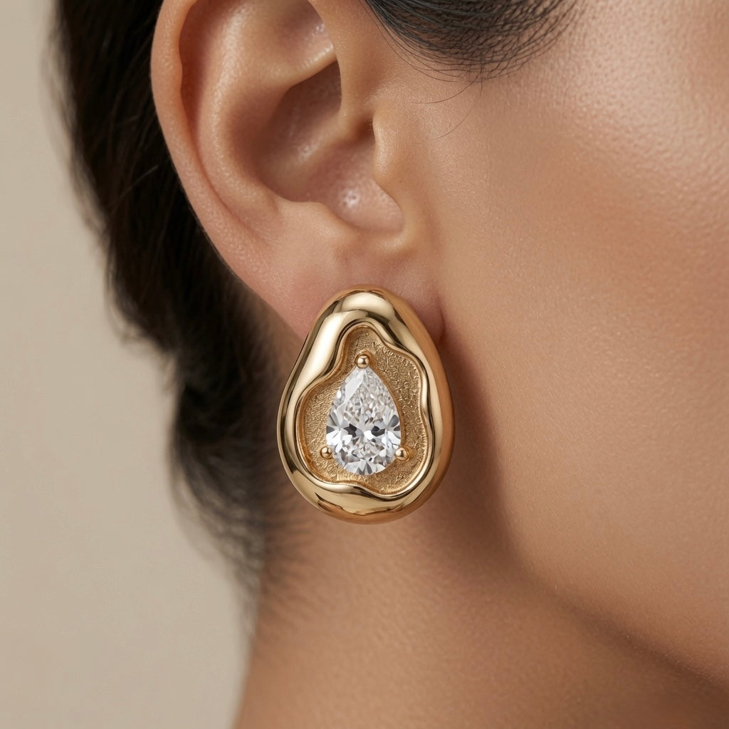 Molten Pear Crystal Stud Earrings - worn on model ear showing scale and sculptural silhouette against neutral backdrop