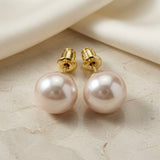 Perle Blush Pearl Stud Earrings - back view on marble with silk showing gold screw-back posts and pearl base cups