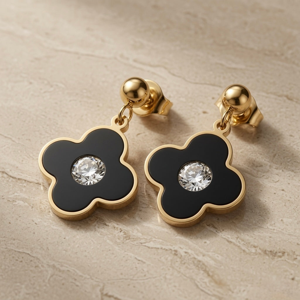 Noir Fleur Crystal Drop Earrings - pair on travertine showing black enamel flower and crystal centre with gold ball stud