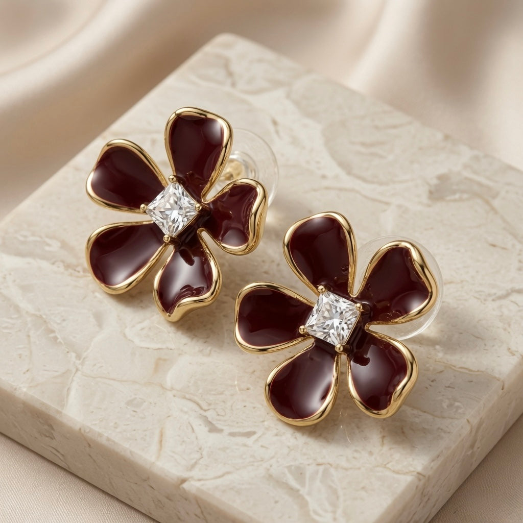 Vigne Crystal Fleur Stud Earrings - pair on marble with silk showing princess-cut crystal centre and burgundy enamel petals
