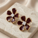 Vigne Crystal Fleur Stud Earrings - pair on marble with silk showing princess-cut crystal centre and burgundy enamel petals