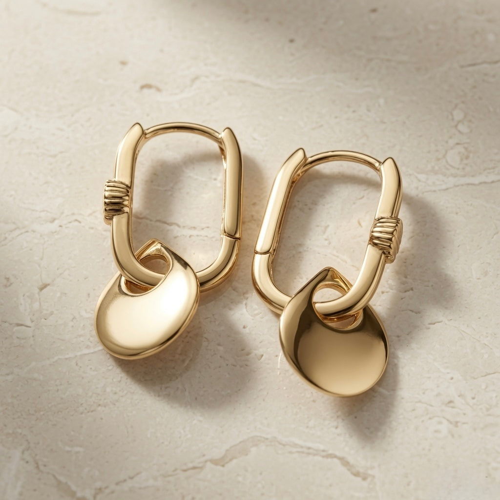 Disque Crystal Huggie Drop Earrings - pair flat lay on marble showing full rectangular hoop profile and disc charm from above