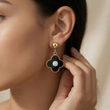 Noir Fleur Crystal Drop Earrings - worn on model ear showing perfect drop length and black and gold contrast against skin
