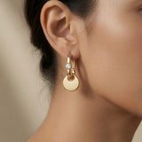 Disque Crystal Huggie Drop Earrings - worn on model ear showing disc drop movement, milgrain crystal and warm gold glow against skin