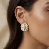 Camélia Blanc Pearl Stud Earrings - worn on model ear showing voluminous three-dimensional camellia bloom and pearl centre against skin