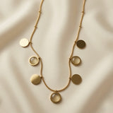 Sept Lunes Disc Station Necklace - close-up flat lay on ivory silk showing alternating gold solid discs and moonstone cabochon circles on satellite ball chain
