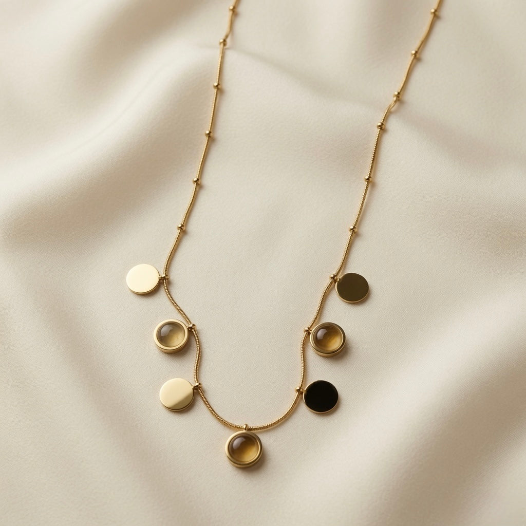 Sept Lunes Disc Station Necklace - flat lay on ivory silk showing full necklace arc with all seven discs, satellite ball stations and chain detail