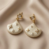Constellation Ivoire Jewellery Set - earring macro on silk showing oval crystal zirconia stud top and ivory enamel fan drop with gold stars and crystal dots