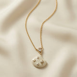 Constellation Ivoire Jewellery Set - necklace macro on silk showing pear crystal bezel connector, ivory enamel fan pendant and constellation motif detail