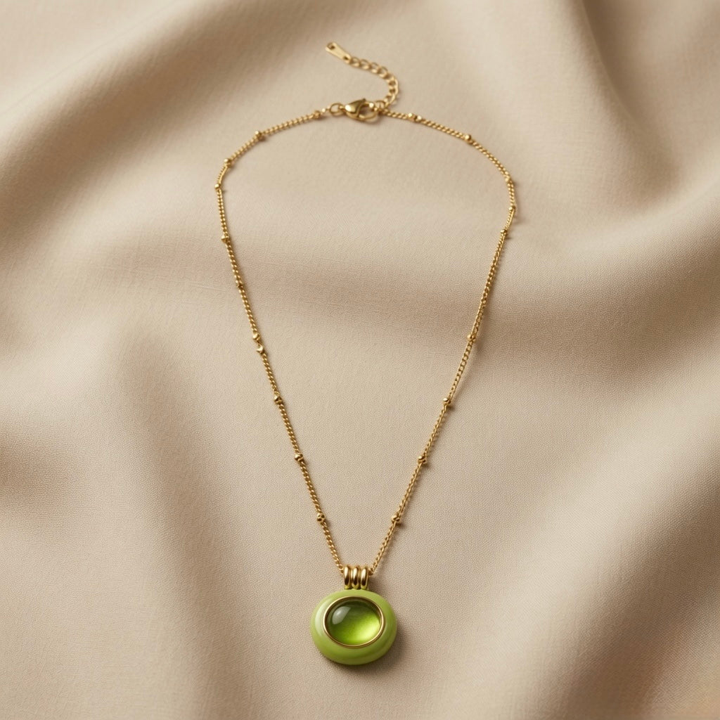 Pistache Cabochon Pendant Necklace - full flat lay on ivory silk showing complete satellite chain and circular pistachio pendant
