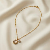 Lune Dorée Crystal Duo Pendant Necklace - full flat lay on ivory silk showing complete satellite ball chain with lobster clasp extender and dual pendant centrepiece of moonstone cabochon and crystal zirconia