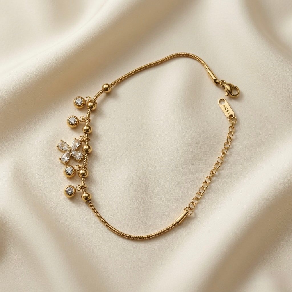 Fleur Cristal Fringe Drop Snake Chain Bracelet - flat lay on ivory silk from alternate angle showing complete bracelet open, Svora logo bar tag on curb extender, lobster clasp and five crystal drop fringe composition