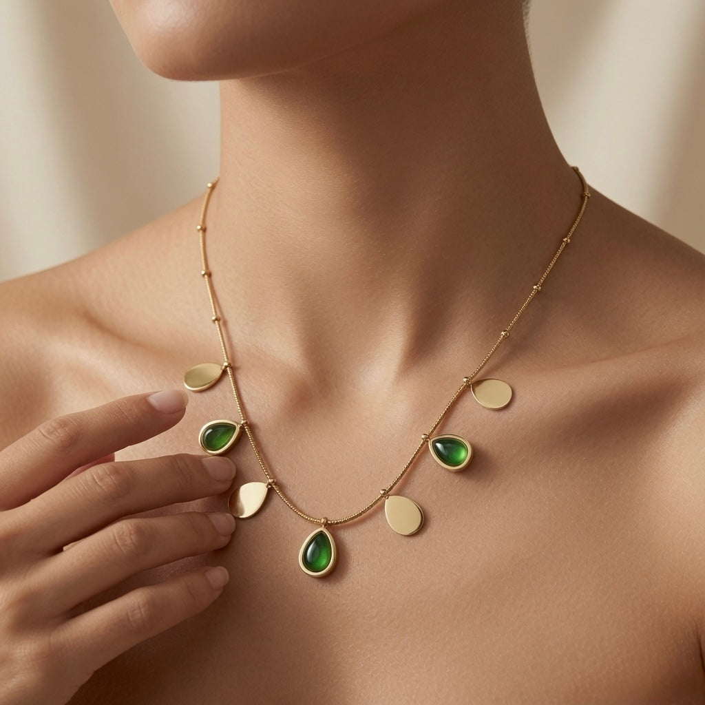 Pluie Verte Charm Necklace Gold & Emerald - worn on model showing seven charms fanning across décolletage in emerald and gold arc