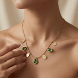 Pluie Verte Charm Necklace Gold & Emerald - worn on model showing seven charms fanning across décolletage in emerald and gold arc